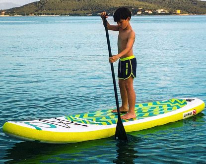 Un bambino si cimenta in un tipico Allenamento Estivo con il SUP